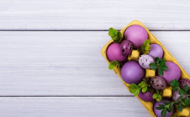 Paskalya yumurtaları, mor ve leylak, beyaz ahşap bir masada, Paskalya kartı, afiş, seçici odak, yatay