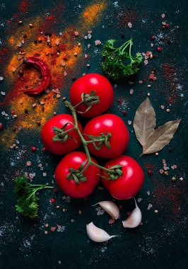 Domates dalı, koyu yeşil arka planda, baharatlar, üst görünüm, yemek arka planı, dikey, insan yok.,