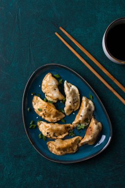 Japon Gyoza hamur tatlısı, kızarmış, soslu, yeşil arka planda, üst manzara, insan yok, tonlanmış, haşlanmış,