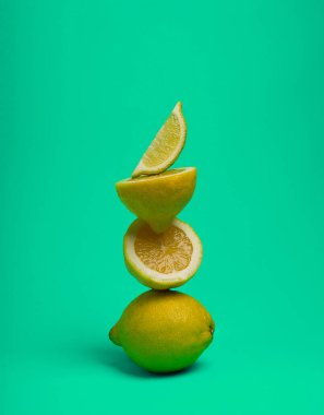 Yeşil arka planda bir yığın limon, dikey, insan yok, yemek geçmişi var.,