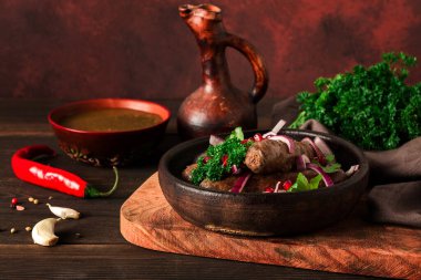 Gürcü yemeği, kızarmış Kupaty sosisi, geleneksel kil tavada Ketsi, yatay, insan yok, seçici odaklı, tonlu. .