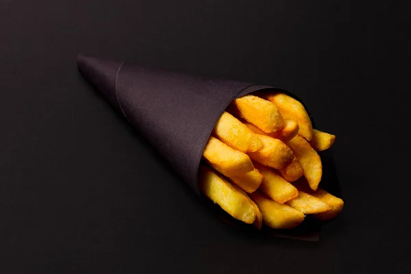 炸薯条 用黑纸包装 背景为黑色 有选择性 — 图库照片