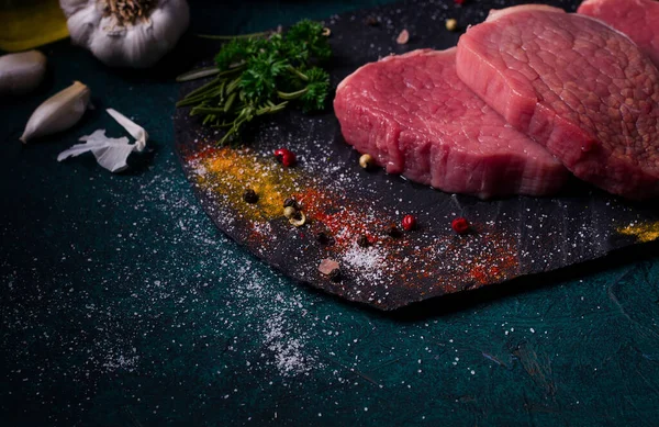 新鮮な生牛肉の肉 メダリオン 黒スレート上 スパイスと クローズアップ — ストック写真