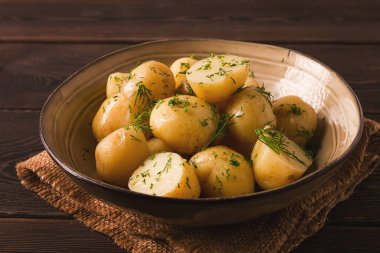 Taze pişmiş, taze patates, dereotlu, ahşap bir masada, seçici bir odak noktası. yakın çekim, tonlama, insan yok,