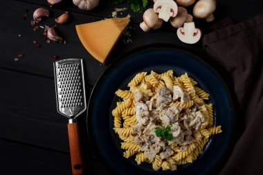 Fusilli makarna, krema soslu, en iyi manzaralı, malzemeli, ahşap bir masada, insan yok.,