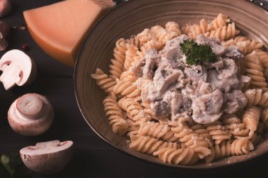 Fusilli makarna, krema soslu, en iyi manzaralı, malzemeli, ahşap bir masada, insan yok.,