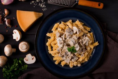 Fusilli makarna, krema soslu, en iyi manzaralı, malzemeli, ahşap bir masada, insan yok.,