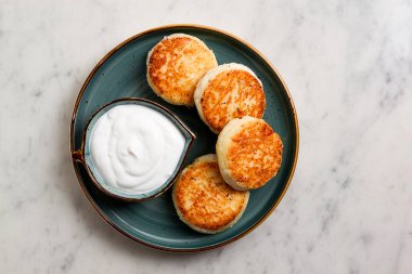 Kızarmış, süzme peynirli krep, ekşi krema, cheesecake, misket masasında, üst manzara, insan yok..