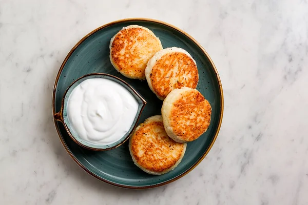 Kızarmış, süzme peynirli krep, ekşi krema, cheesecake, misket masasında, üst manzara, insan yok..