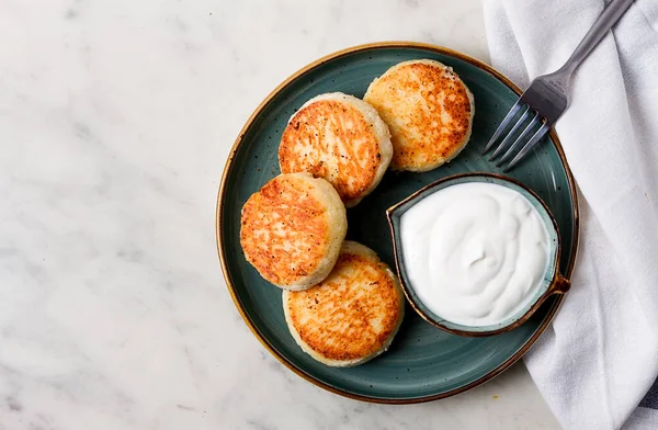 Kızarmış, süzme peynirli krep, ekşi krema, cheesecake, misket masasında, üst manzara, insan yok..