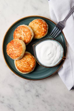 Kızarmış, süzme peynirli krep, ekşi krema, cheesecake, misket masasında, üst manzara, insan yok..