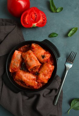 Domates soslu lahana ruloları doldurulmuş lahana yaprakları, pirinçli kıyma, koyu bir arka plan, üst manzara, insan yok.,