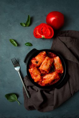 Domates soslu lahana ruloları doldurulmuş lahana yaprakları, pirinçli kıyma, koyu bir arka plan, üst manzara, insan yok.,