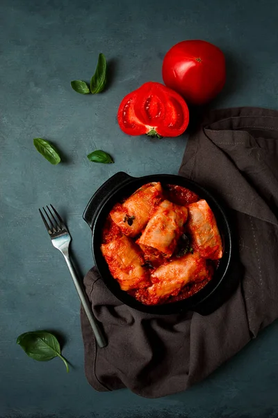 Domates soslu lahana ruloları doldurulmuş lahana yaprakları, pirinçli kıyma, koyu bir arka plan, üst manzara, insan yok.,