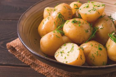Taze pişmiş, taze patates, dereotlu, ahşap bir masada, seçici bir odak noktası. yakın çekim, tonlama, insan yok,