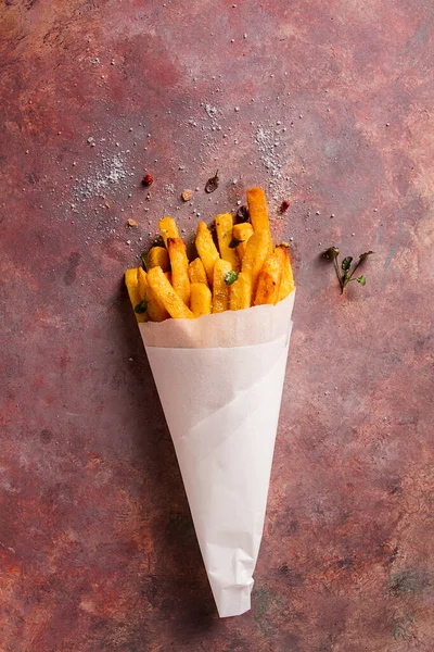 Kızarmış patates kızartması, kağıt torbada, soyut bir arka planda, insan yok, kırsal kesimde.,