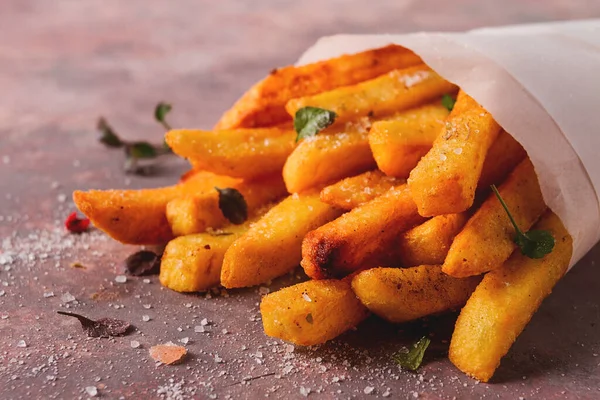 Kızarmış patates kızartması, kağıt torbada, soyut bir arka planda, insan yok, kırsal kesimde.,