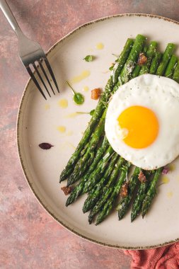 ızgara kuşkonmaz, kızarmış yumurta, baharat ve otlar, parmesan peyniri, bej bir tabakta, üst manzara, kırsal, insan yok.