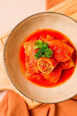 Doldurulmuş lahana ruloları, kıymalı, domates soslu, bej arka planda, yiyecek ve içecek, sağlıklı beslenme, sağlıklı yaşam tarzı, mutfak, kırsal, lahana rulosu, üst görünüm, insan yok.,
