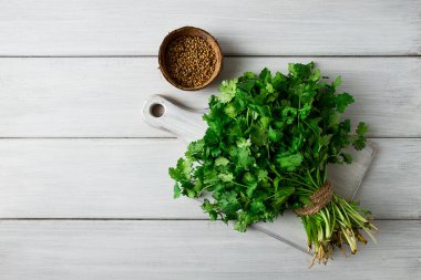 Bir grup taze Cilantro, beyaz ahşap bir masada, yakın plan, üst manzara, insan yok..