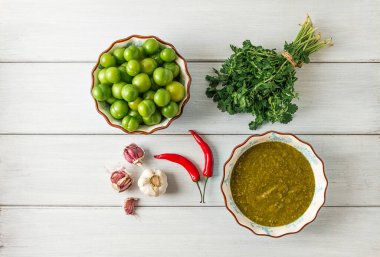 Tkemali sosu, geleneksel Gürcü mutfağı, yeşil kiraz eriği, sos malzemeleri, kişniş, nane, acı biber, sarımsak, beyaz ahşap bir masa üzerinde, yakın plan, kırsal, gıda arka planı, insan yok, seçici odak, sos, yeşil sos, tkemali, georg