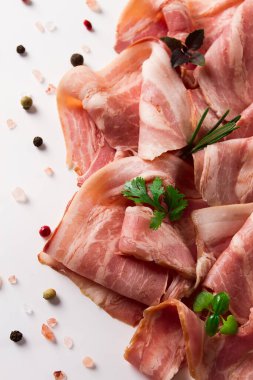 Çiğ pastırma, dilimlenmiş, mikro yeşil ve baharatlı, beyaz arka planda, yakın plan.,