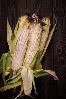 Mısır koçanları, ahşap bir masa, üst görünüm, yakın çekim, kırsal, seçici odak, süt ürünü mısır,