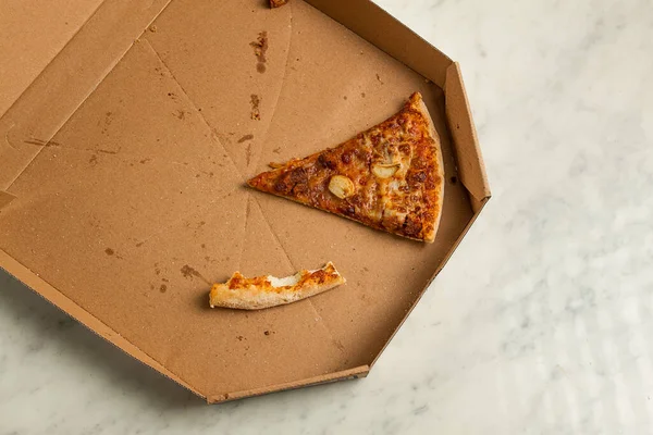 Pizza box, on the table, with one piece and a crust, leftovers, top view, no people,