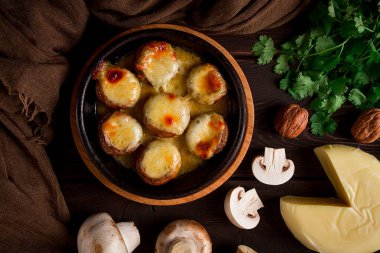 Geleneksel Gürcü yemeği, aperatif, mantar dolması, Sulguni peyniri, Ketzi kil tavasında pişirilmiş, ahşap bir masada, yakın plan, insan yok.,