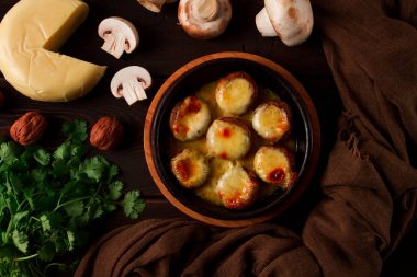 Geleneksel Gürcü yemeği, aperatif, mantar dolması, Sulguni peyniri, Ketzi kil tavasında pişirilmiş, ahşap bir masada, yakın plan, insan yok.,