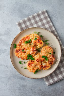 Biftek, karnabahar, peynirli, baharatlı, ev yapımı, açık gri bir masada, yakın çekim, üst görüş, seçici odak, insan yok.,