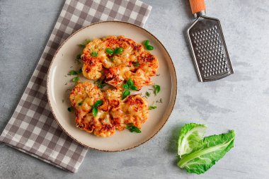 Biftek, karnabahar, peynirli, baharatlı, ev yapımı, açık gri bir masada, yakın çekim, üst görüş, seçici odak, insan yok.,