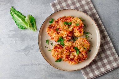 Biftek, karnabahar, peynirli, baharatlı, ev yapımı, açık gri bir masada, yakın çekim, üst görüş, seçici odak, insan yok.,