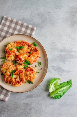 Biftek, karnabahar, peynirli, baharatlı, ev yapımı, açık gri bir masada, yakın çekim, üst görüş, seçici odak, insan yok.,