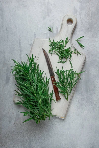 Fresh Tarragon, on a cutting board, slicing, on a light table, top view, no people,