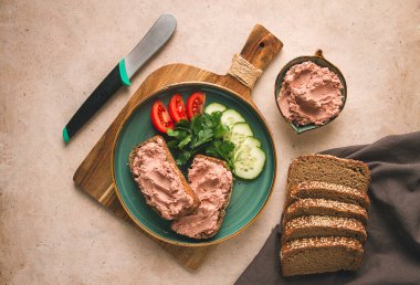 Çavdar ekmeğine sürülmüş karaciğer eti ezmesi, kahvaltı, yakın plan, bej arka plan. İnsanlar yok, seçici odaklanma,