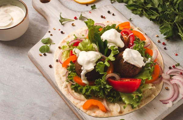 Tortilla with falafel and vegetable salad, white sauce, Arabic cuisine, top view, homemade, no people, vegetarian food,