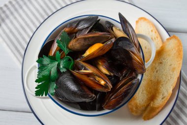 Fresh, Boiled mussels, Black Sea, with white bread, on a white wooden table, no people,
