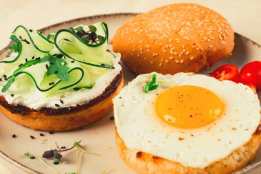 Assortment of sandwiches, white bread, fried egg, cream cheese and cucumber, capelin caviar, sesame bun, breakfast, on a white table, no people,