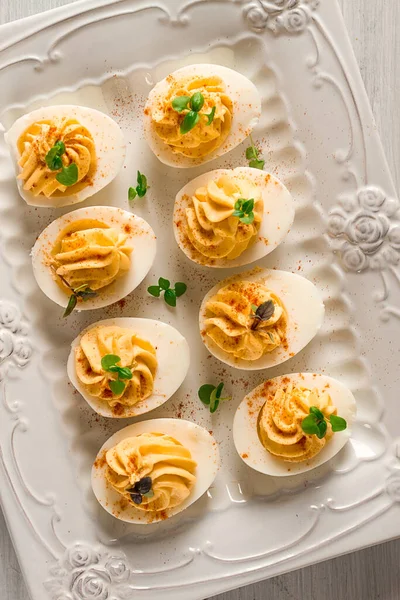 Boiled eggs stuffed with yolk with mayonnaise, on a white plate, selective focus, blurry, close-up, no people,