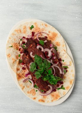 Lula kebap, lavaş, kırmızı soğan, nar ve sumac, üst manzara, yakın çekim, yatay, insan yok.,