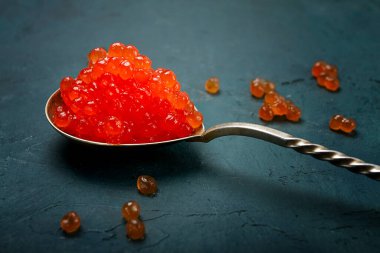 Kırmızı havyarlı kaşıklar, taklit, karanlık arka planda, insan yok.,