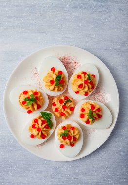 Doldurulmuş yumurta, kırmızı havyar, mikro yeşillik, aperatif, beyaz tabakta, üst manzara, yakın çekim, insan yok.,