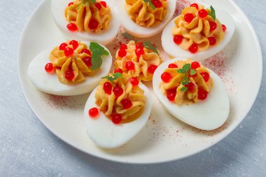 Doldurulmuş yumurta, kırmızı havyar, mikro yeşillik, aperatif, beyaz tabakta, üst manzara, yakın çekim, insan yok.,