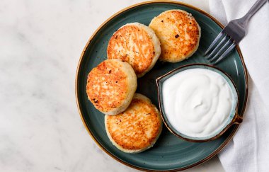 Kızarmış, süzme peynirli krep, ekşi krema, cheesecake, misket masasında, üst manzara, insan yok..