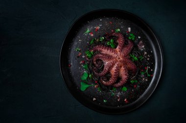 Siyah spagetti, makarna, baharat ve otlu ahtapot, üst manzara, insan yok.,