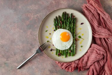 ızgara kuşkonmaz, kızarmış yumurta, baharat ve otlar, parmesan peyniri, bej bir tabakta, üst manzara, kırsal, insan yok.