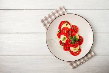 Caprese salad, Italian traditional dish, tomatoes with mozzarella cheese, basil and spices, top view, no people,