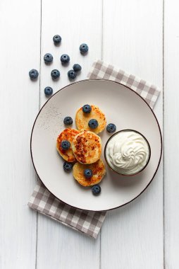Süzme peynirli krepler, yabanmersinli, kahvaltı, beyaz ahşap bir masada, insan yok, üst manzara,