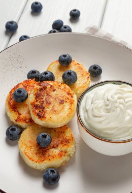 Süzme peynirli krepler, yabanmersinli, kahvaltı, beyaz ahşap bir masada, insan yok, üst manzara,